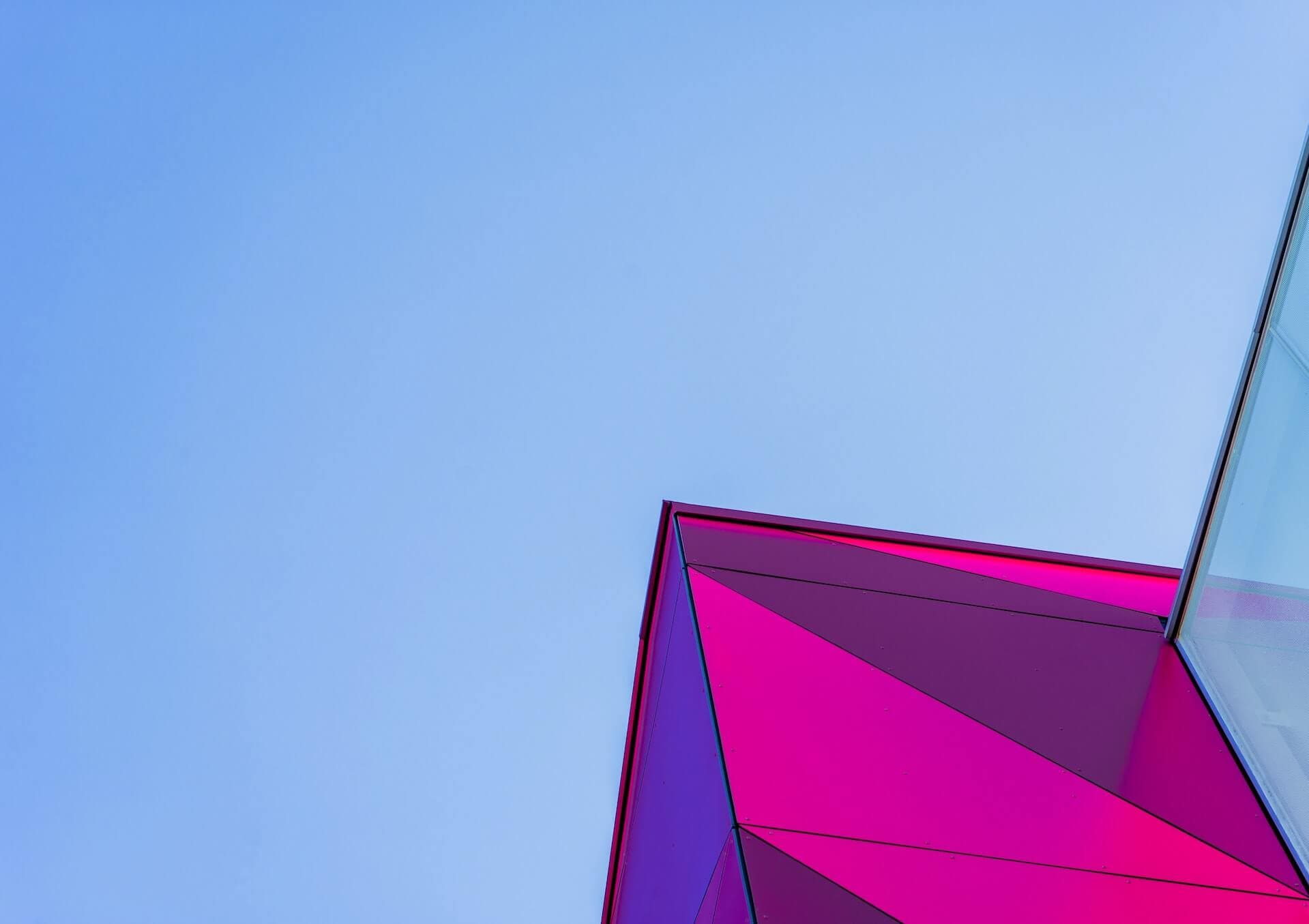 Magenta futuristic architecture against a blue sky